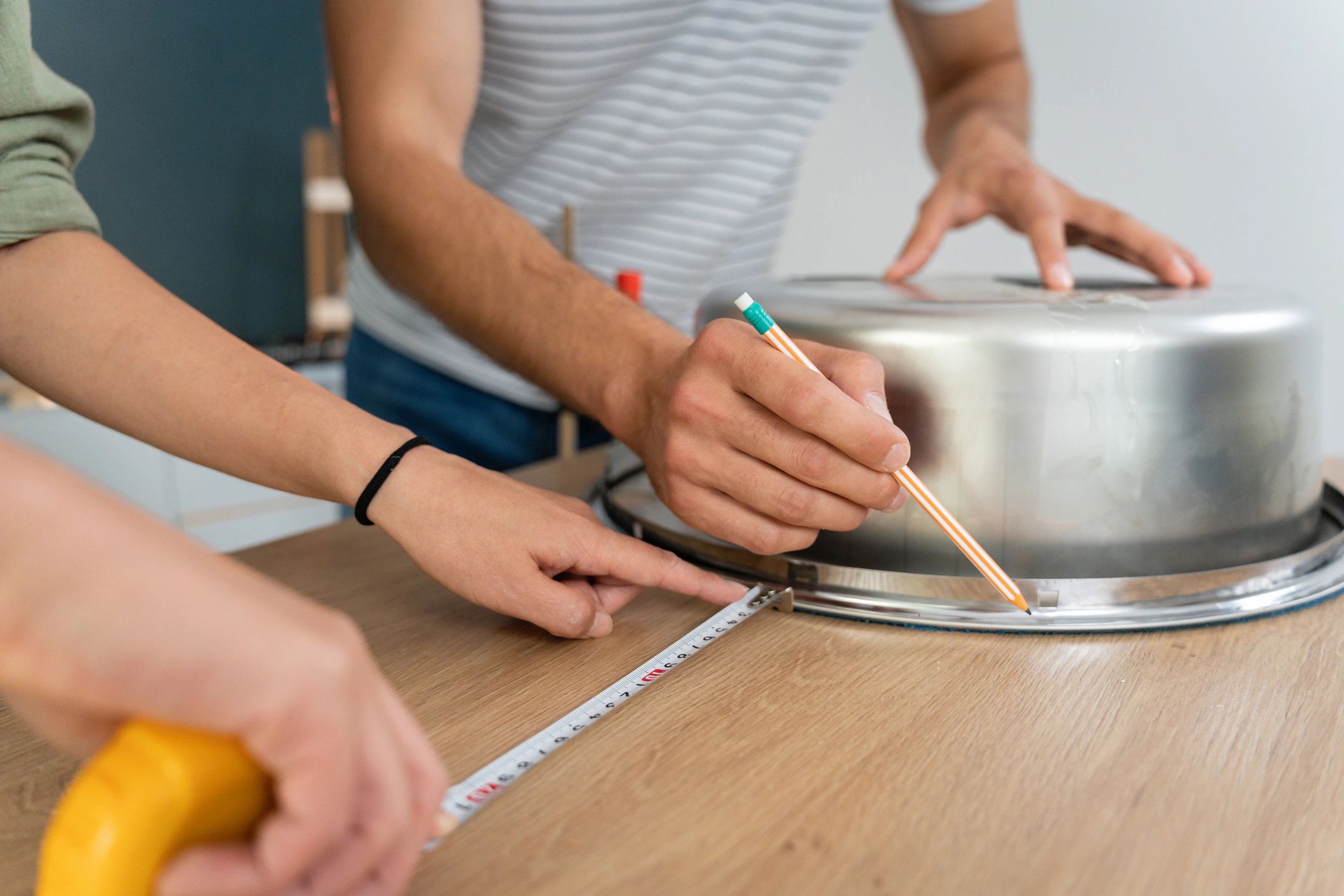 Homeowners measuring and planning a kitchen counter renovation