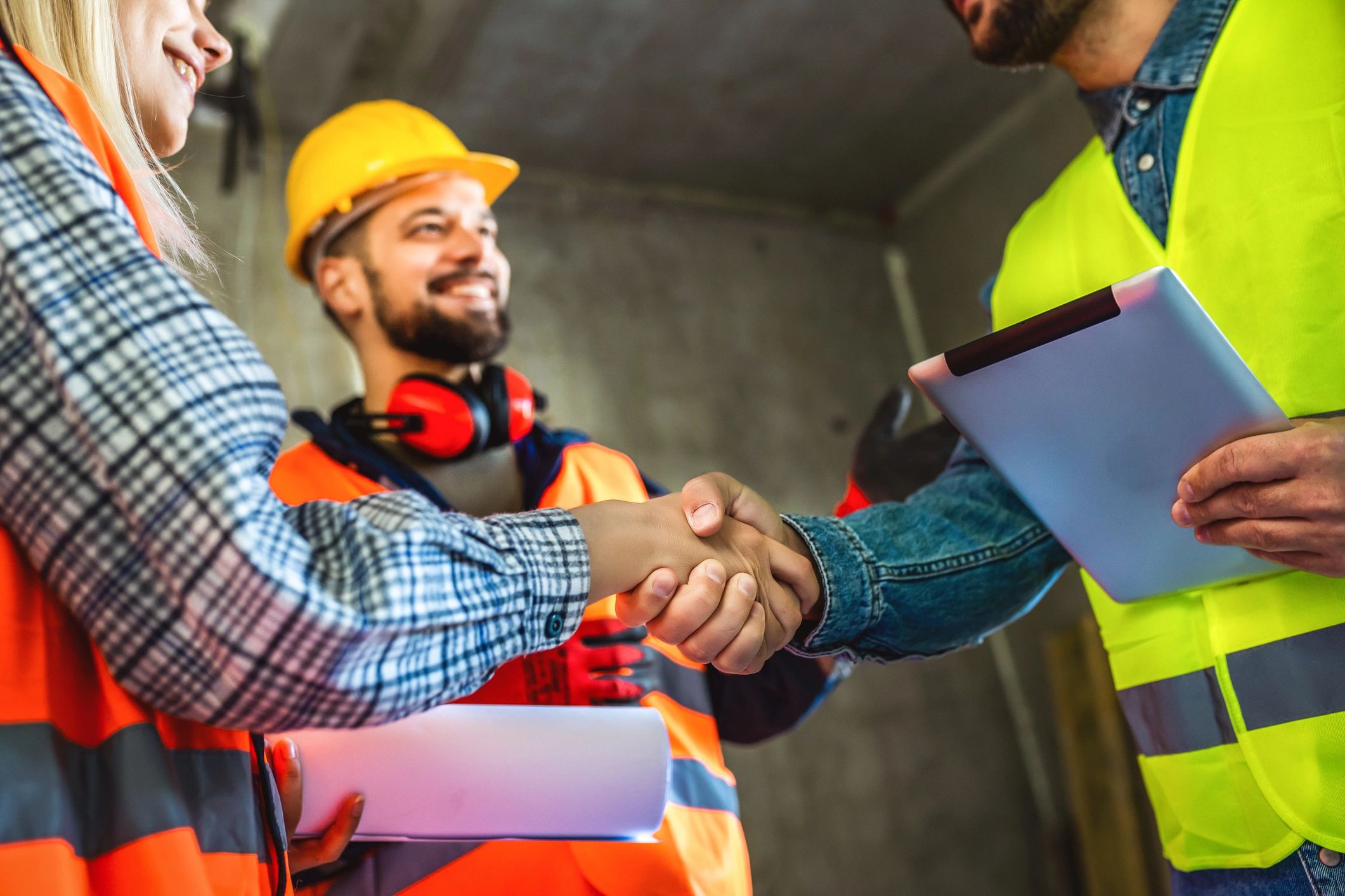 Construction team handshake at a jobsite after reviewing plans